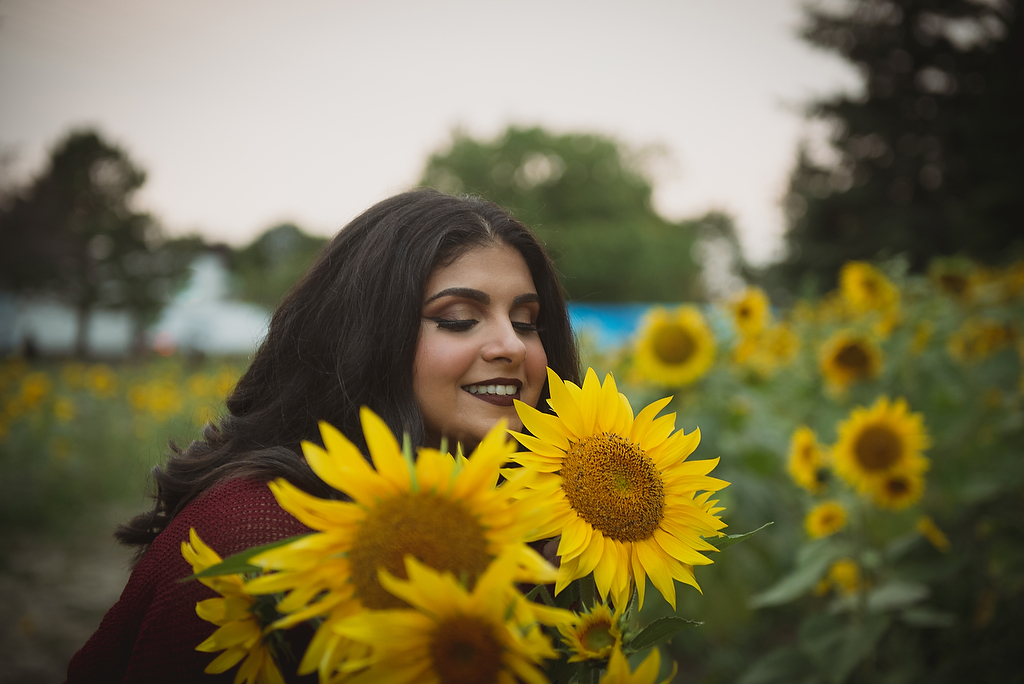 A woman poses with yellow sunflowers in Mississauga Ontario